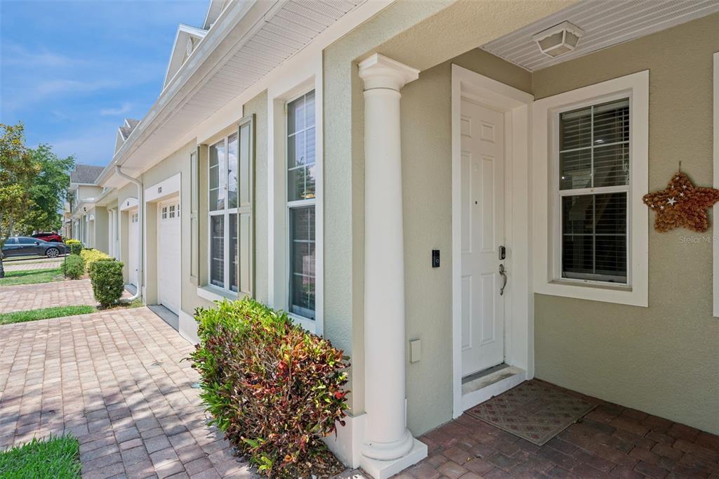 The exterior of a house features a white front door, a column, and a driveway — 4880 POOLSIDE DRIVE, ST CLOUD, FL