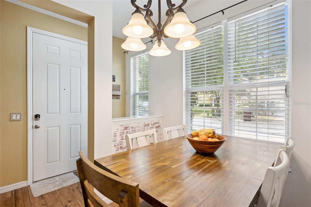A dining area features a wooden table, a chandelier, and windows with white blinds — 4880 POOLSIDE DRIVE, ST CLOUD, FL