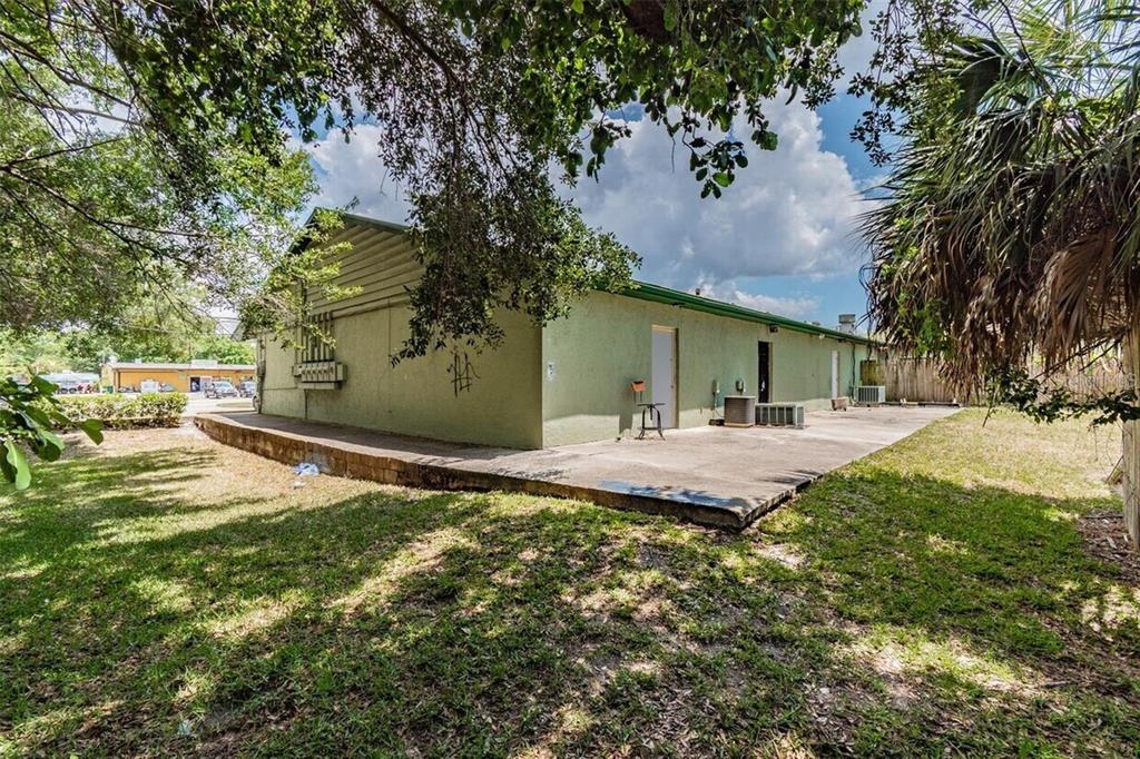 The exterior of a green building features a concrete patio and a grassy yard — 3020 15TH STREET E, BRADENTON, FL