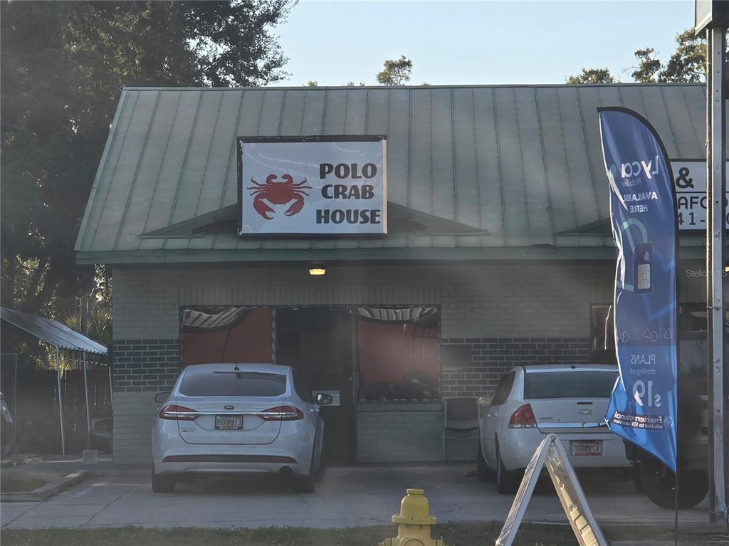 The exterior of a brick building with a metal roof and a crab sign — 3020 15TH STREET E, BRADENTON, FL