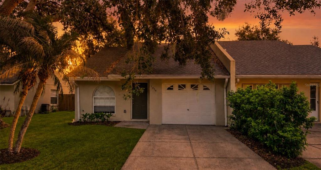A single-story house exterior with a garage, a front door, and a concrete driveway — 1434 SHIRLEY DRIVE, LAKELAND, FL