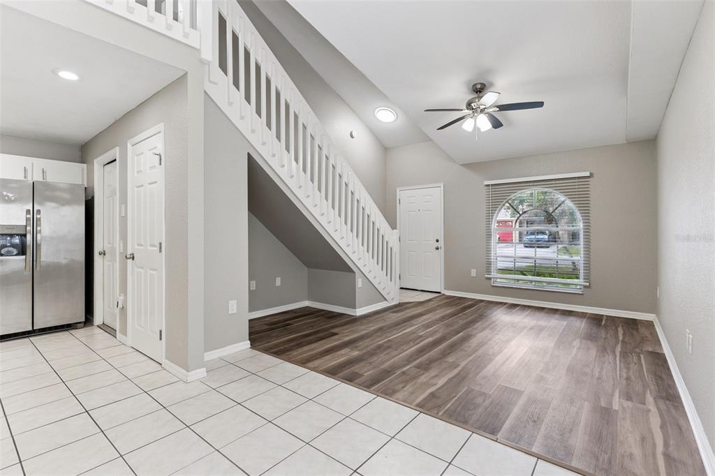 A living room with wood-look flooring, a staircase, and a white front door — 1434 SHIRLEY DRIVE, LAKELAND, FL