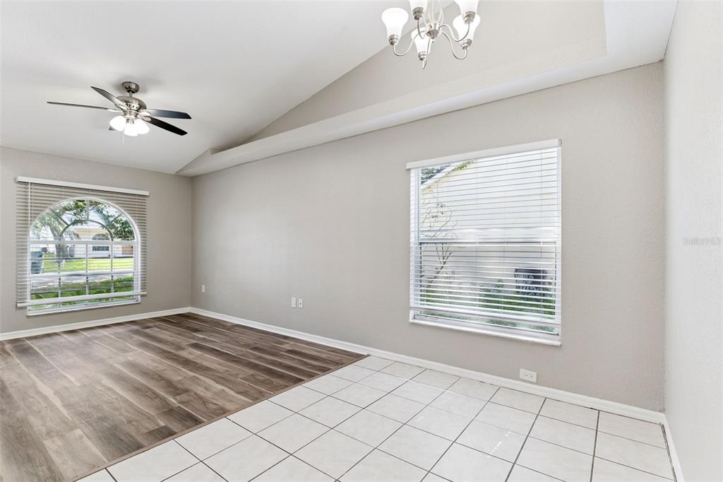 A room with a vaulted ceiling, a ceiling fan, and a mix of wood and tile flooring — 1434 SHIRLEY DRIVE, LAKELAND, FL
