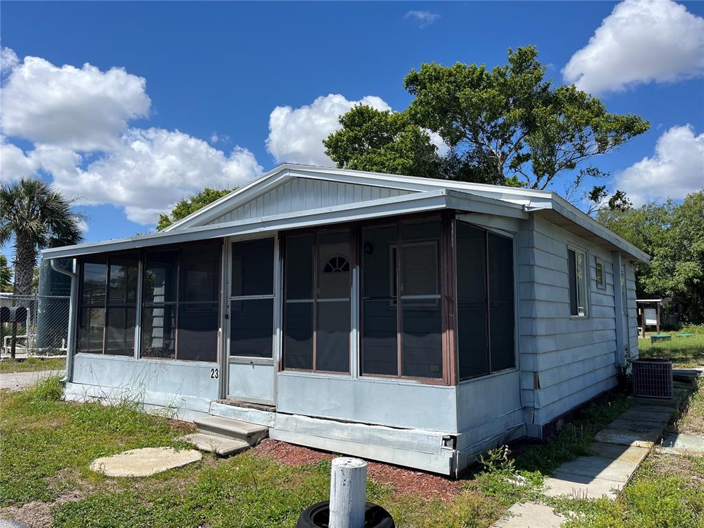 A light blue mobile home features a screened-in front porch and a metal roof — 3731 STATE ROAD 60 E UNIT 23, LAKE WALES, FL