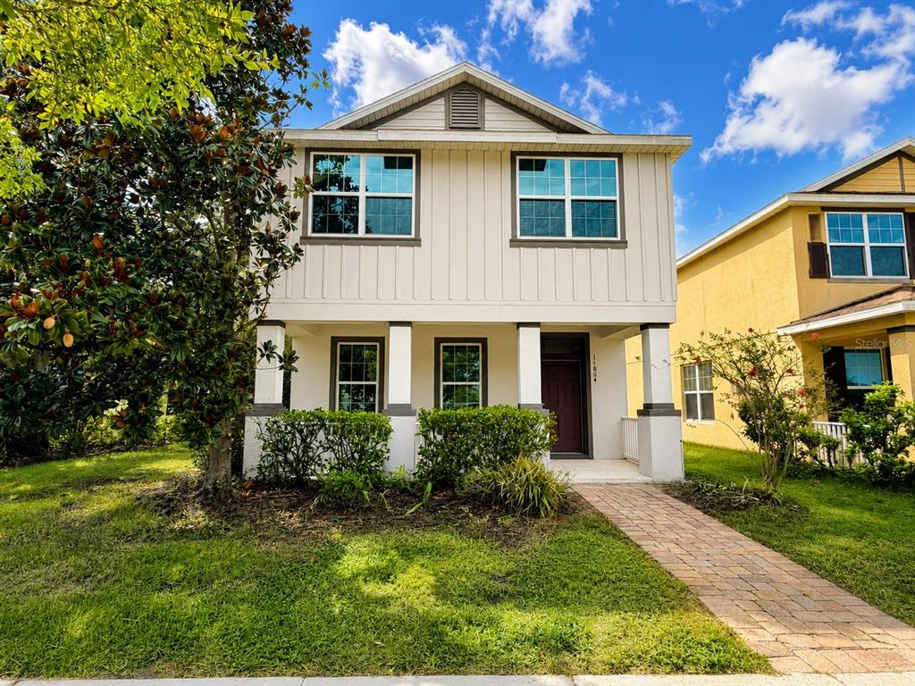 A two-story house with light siding, a covered front porch, and a brick walkway — 11804 SILVERLAKE PARK DRIVE, WINDERMERE, FL