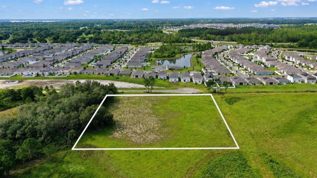 An aerial view shows a rectangular plot of vacant land outlined in white near a subdivision — BOWEN ROAD, DAVENPORT, FL