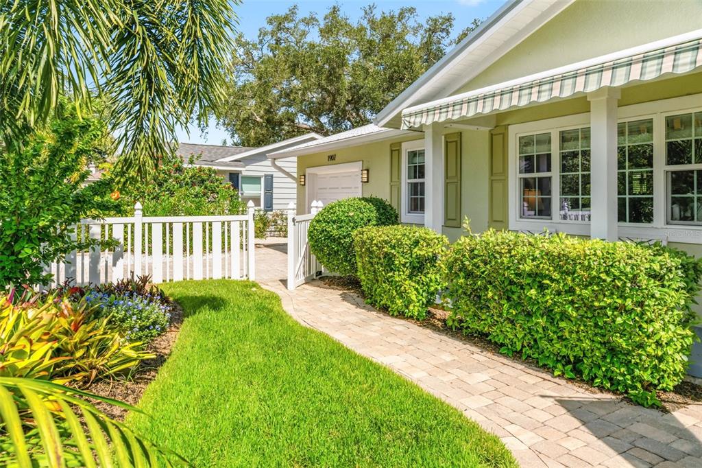 A paved walkway leads to the front entrance of a light green house with white trim — 1907 MAGNOLIA STREET, SARASOTA, FL