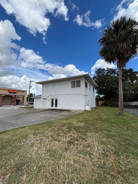 A two-story white building with a flat roof stands next to a tall palm tree — 1871 S RIDGEWOOD AVENUE, SOUTH DAYTONA, FL