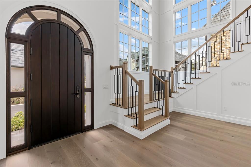 A two-story house features a stone and stucco exterior with a dark shingled roof — 10335 WINTER SPARKLE CIRCLE, GOLDEN OAK, FL