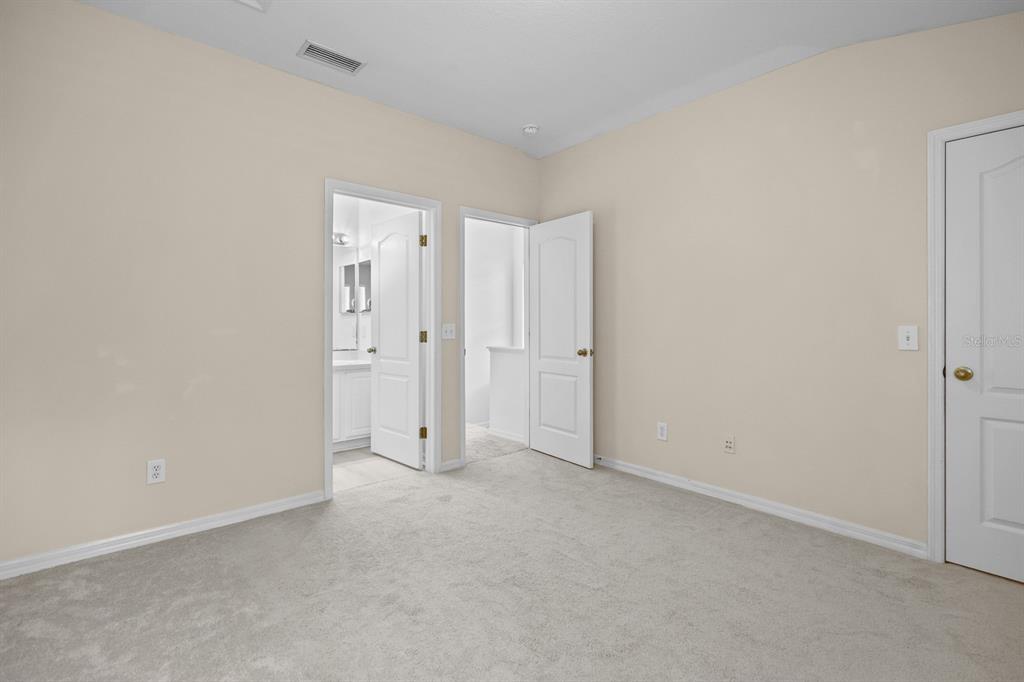A kitchen with white cabinets, stainless steel appliances, and a sliding glass door to outside — 5879 FISHHAWK RIDGE DRIVE, LITHIA, FL