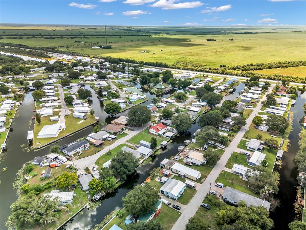 An aerial view shows a residential neighborhood with houses situated along narrow, interconnected canals — 1212 9TH STREET, OKEECHOBEE, FL