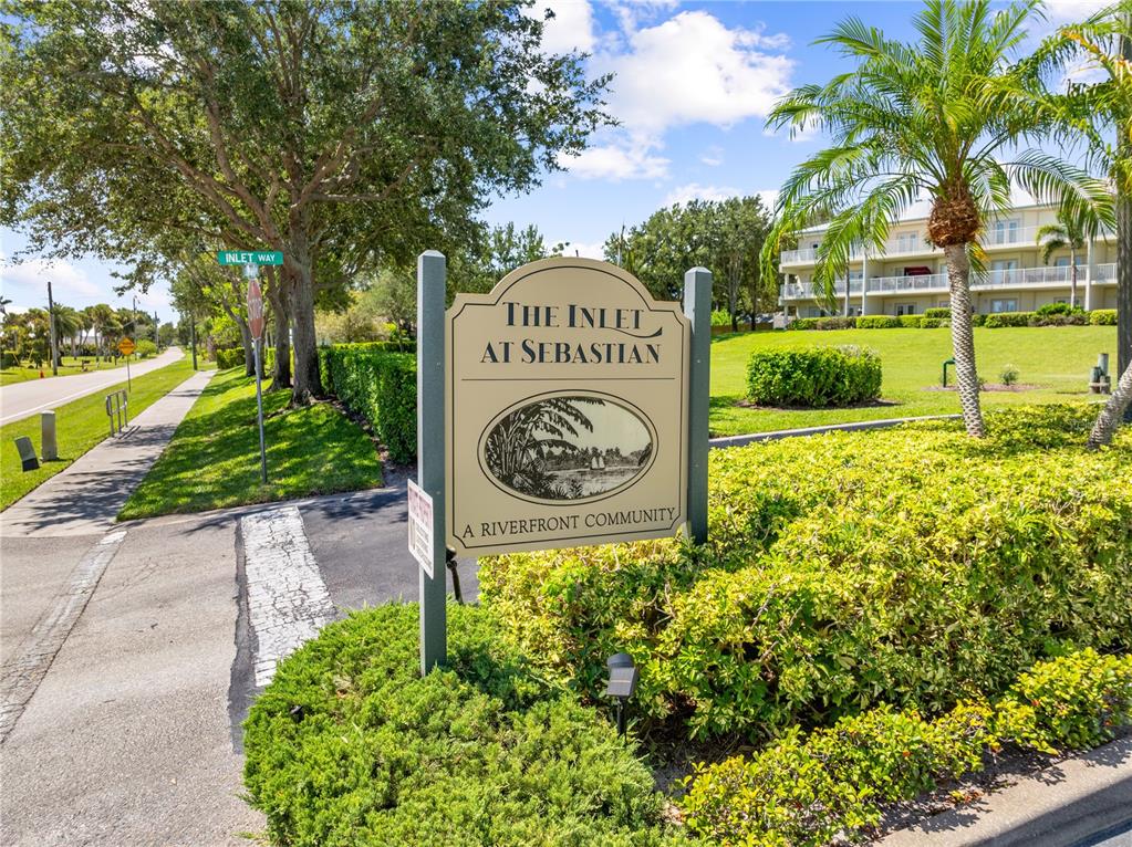 A sign for The Inlet at Sebastian community stands near a sidewalk and palm tree — 13570 MYSTIC DRIVE UNIT 102, SEBASTIAN, FL