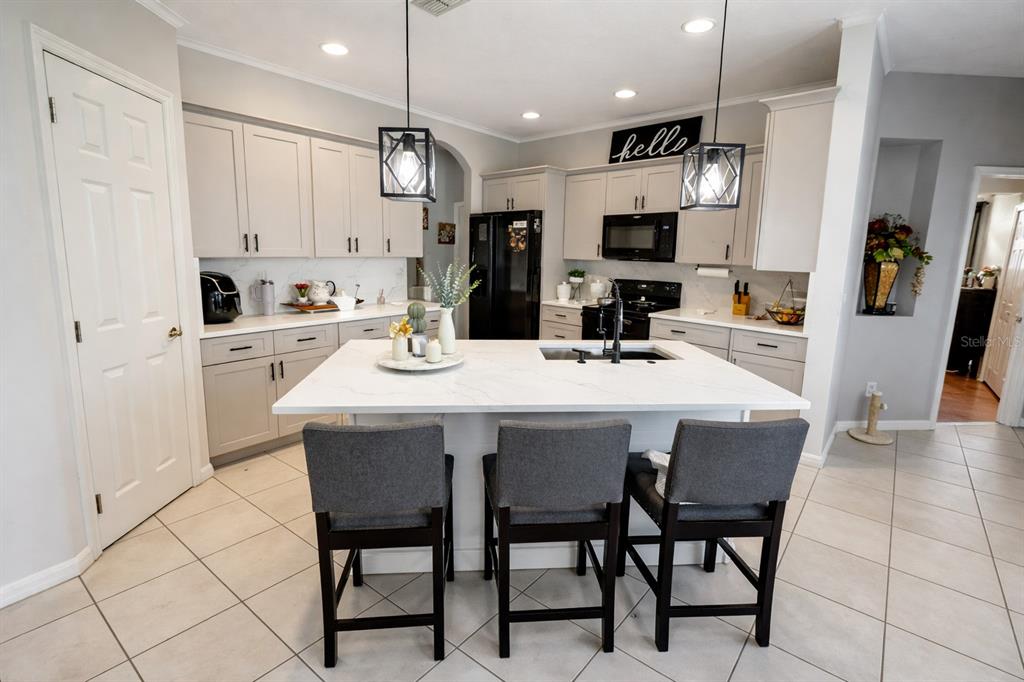 A dining room features a dark wood table, upholstered chairs, and hardwood flooring — 2601 GOLD DUST CIRCLE, KISSIMMEE, FL