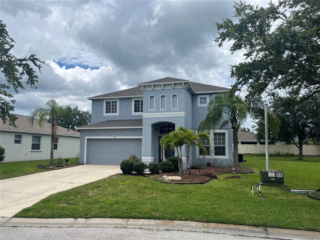 A two-story blue house with a two-car garage and a front lawn — 5966 WILLOWS BRIDGE LOOP, ELLENTON, FL