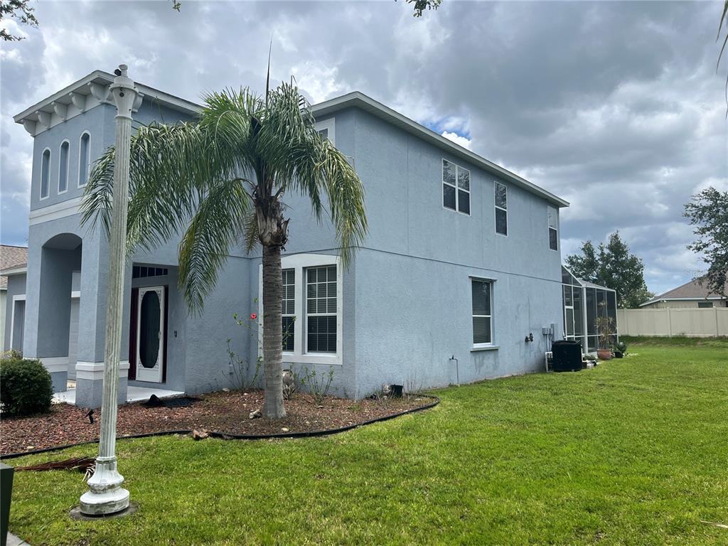 A two-story blue stucco house features a palm tree in the front yard — 5966 WILLOWS BRIDGE LOOP, ELLENTON, FL