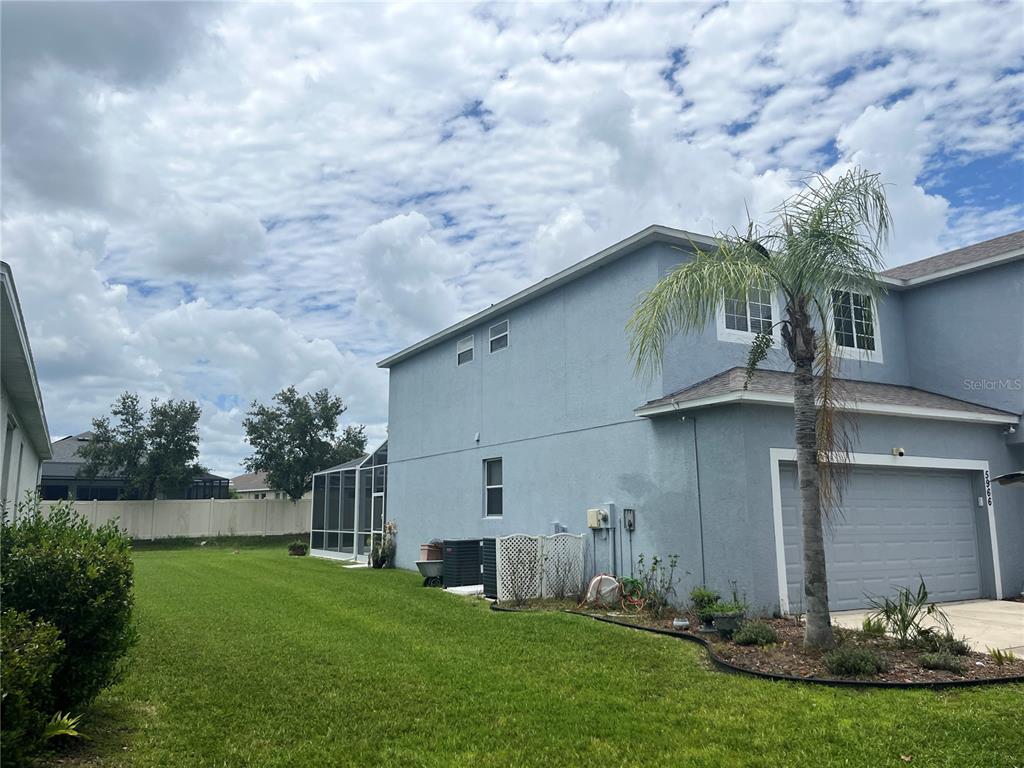 A two-story blue house with a screened-in patio and a palm tree in the yard — 5966 WILLOWS BRIDGE LOOP, ELLENTON, FL