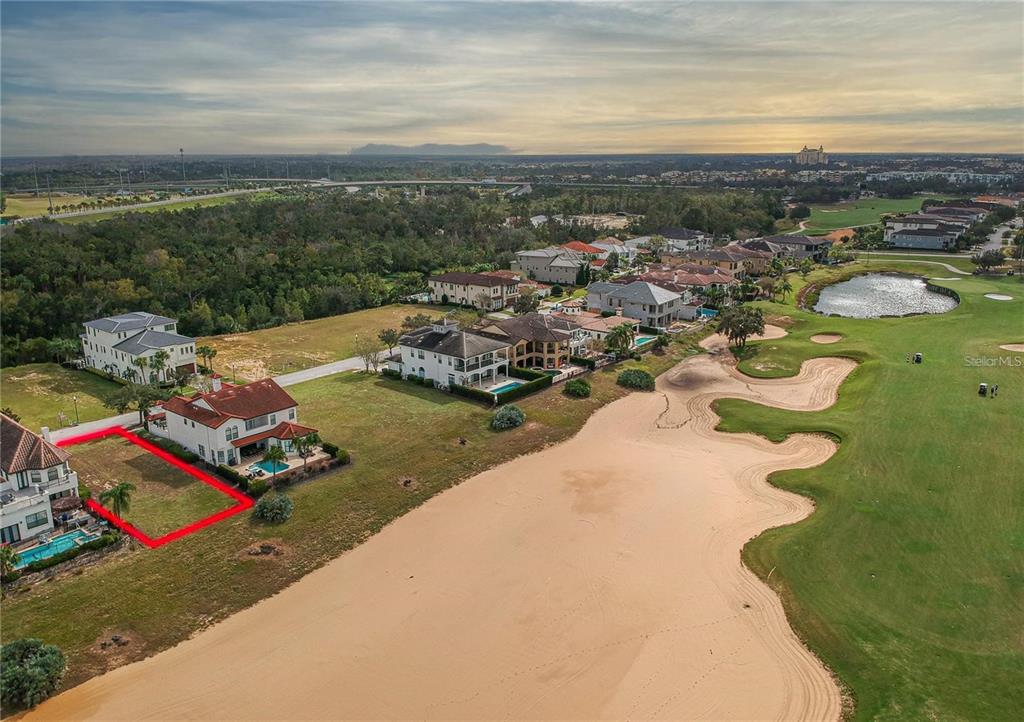 An aerial view shows a vacant residential lot outlined in red next to a house — 541 MUIRFIELD LOOP, REUNION, FL