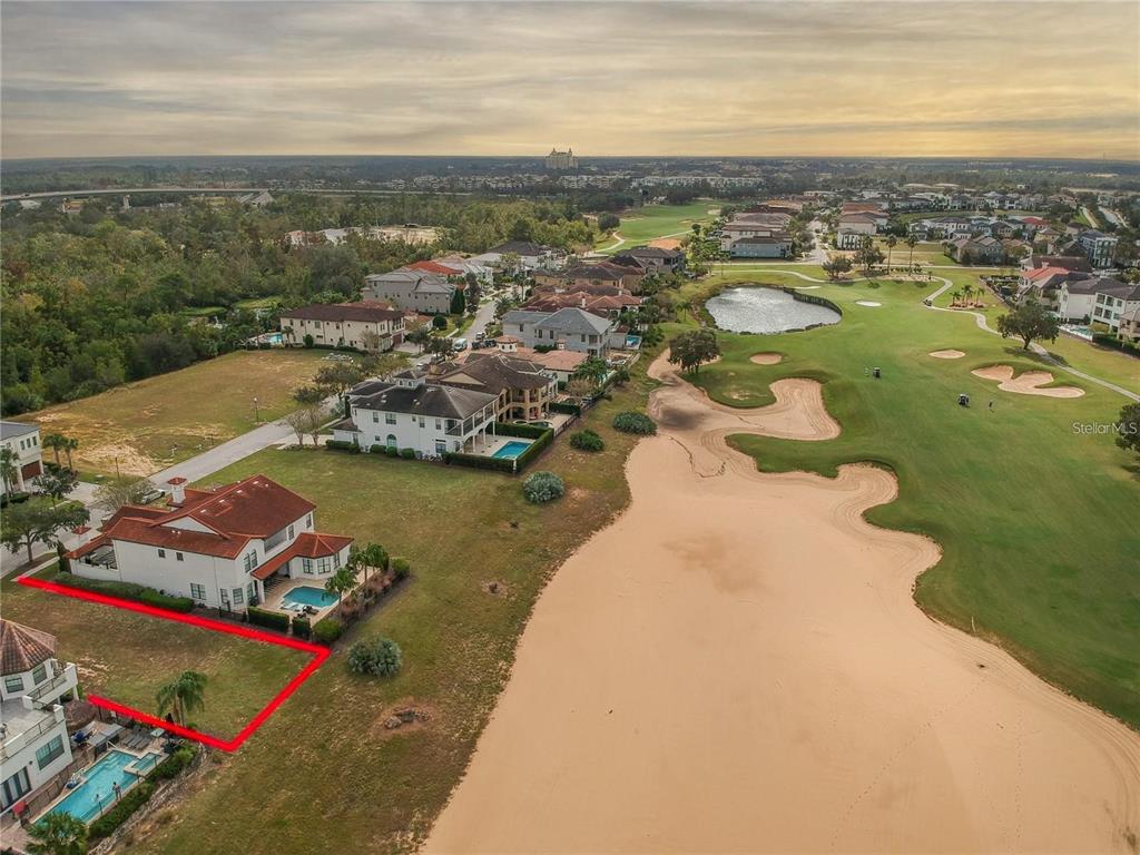 An aerial view shows a residential lot outlined in red next to a golf course — 541 MUIRFIELD LOOP, REUNION, FL