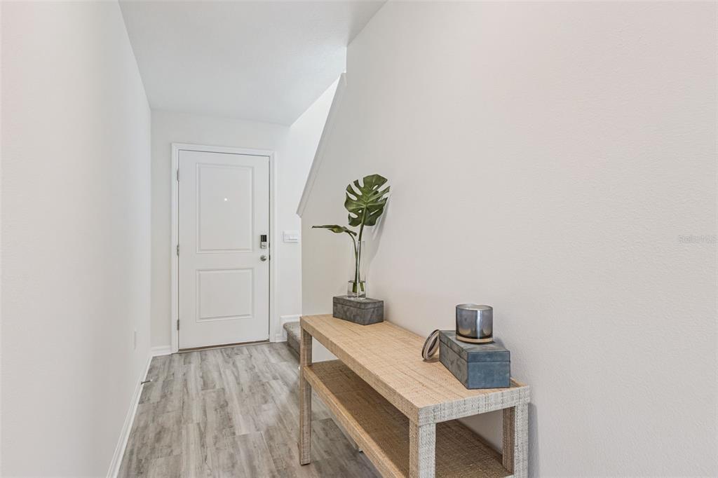 A white front door opens into a foyer with light wood-look flooring and a console table — 4714 TONY STREET, LAKE WALES, FL