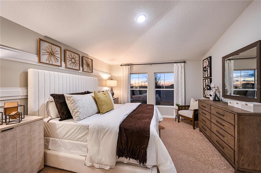 A bedroom features a white upholstered headboard, a wooden dresser, and two windows with curtains — 4184 RIVER BEACON BOULEVARD, DAVENPORT, FL