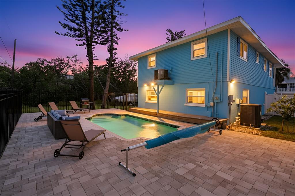 A two-story blue house with a white balcony, garage, and outdoor staircase sits on grass — 2915 AVENUE C, HOLMES BEACH, FL