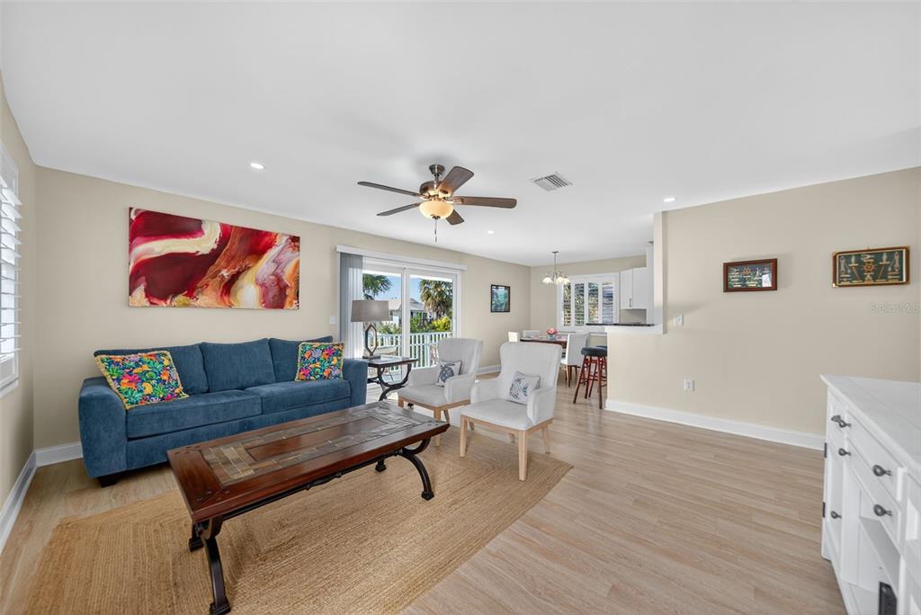 A two-story light blue house with a balcony, garage, and palm trees at dusk — 2915 AVENUE C, HOLMES BEACH, FL