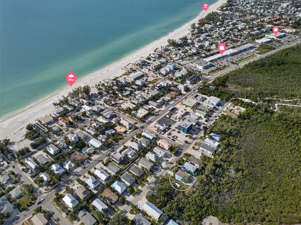 A two-story blue house with a white balcony, garage, and palm trees in the front yard — 2915 AVENUE C, HOLMES BEACH, FL