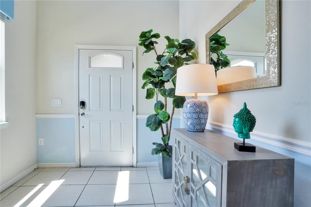 A kitchen with dark cabinets, granite countertops, a breakfast bar, and an adjacent dining area — 8936 PRAGUE WAY, KISSIMMEE, FL