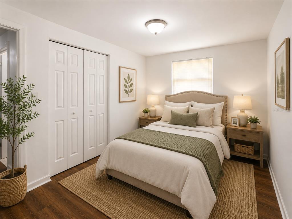A bedroom with a bed, two nightstands, a closet, and a window with blinds — 2318 E 111TH AVE, TAMPA, FL