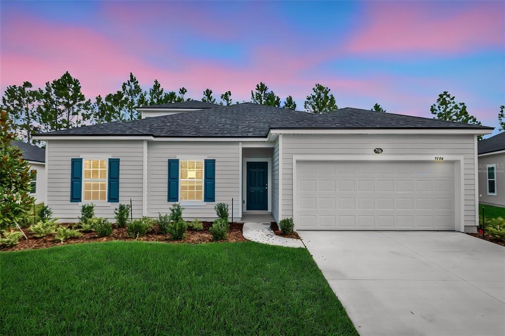 A single-story house with light gray siding, a two-car garage, and blue shutters — 2764 LAUREL FALLS DRIVE, GREEN COVE SPRINGS, FL