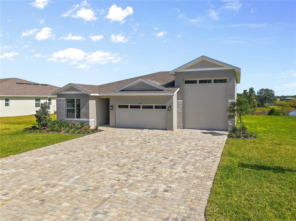 A single-story house with a paved driveway, a two-car garage, and a separate side-entry garage — 9120 PLAYERS DRIVE, WEEKI WACHEE, FL
