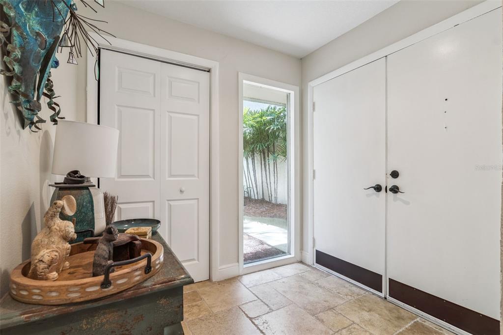An entryway with tile flooring, a white double door, a side window, and a console table — 117 RED CEDAR DRIVE, LONGWOOD, FL