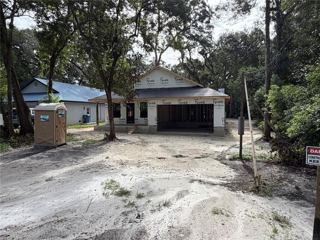 A covered patio features a stone fireplace, a ceiling fan, and a wooden deck — 478 LINCOLN AVENUE, BROOKSVILLE, FL