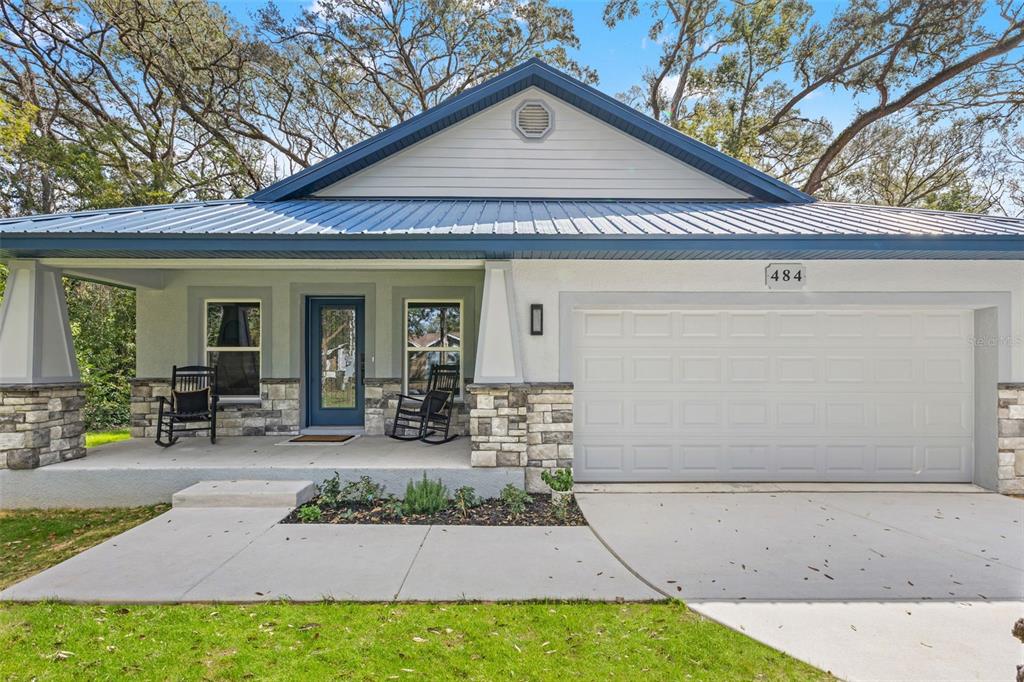 A kitchen with blue cabinets and a white countertop features a blue-and-white marbled epoxy floor — 478 LINCOLN AVENUE, BROOKSVILLE, FL