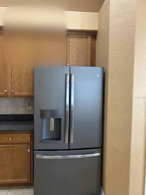A stainless steel French door refrigerator is positioned next to oak kitchen cabinets — 210 ROSANA DRIVE, BRANDON, FL