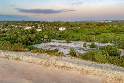 An aerial view shows a vacant sandy lot situated between a beach and a road — 6965 HIGHWAY A1A, MELBOURNE BEACH, FL