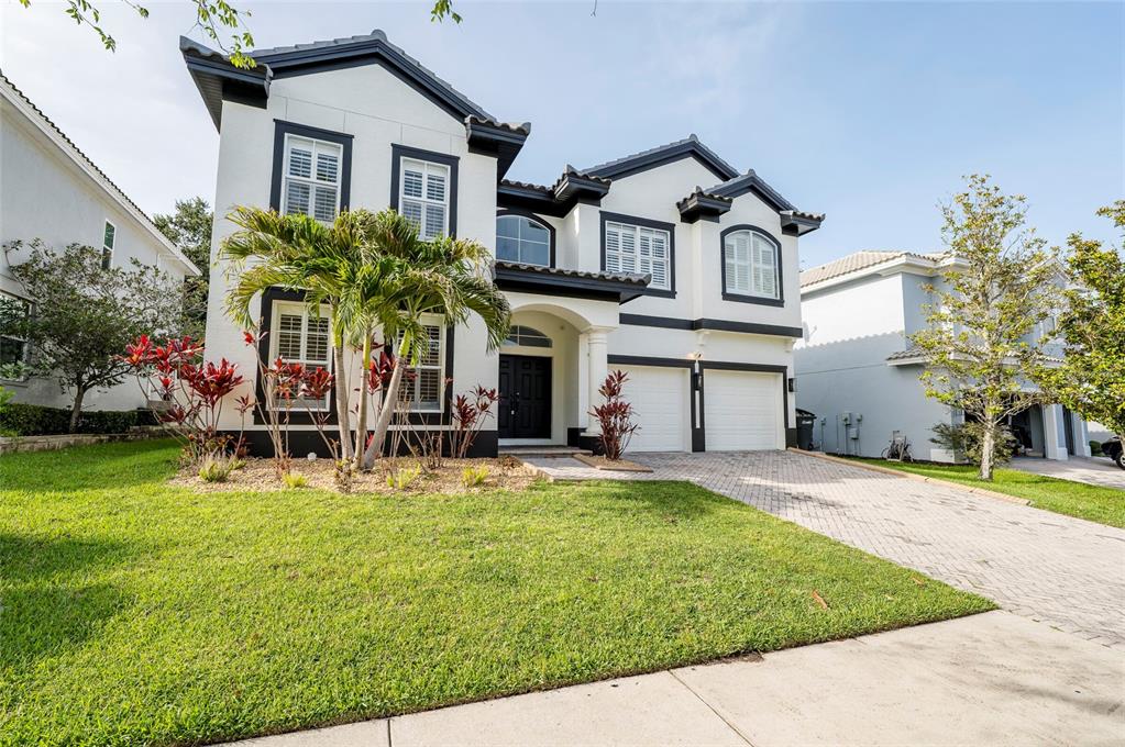 A two-story white house with black trim, a two-car garage, and a front lawn — 2348 MESSENGER CIRCLE, SAFETY HARBOR, FL