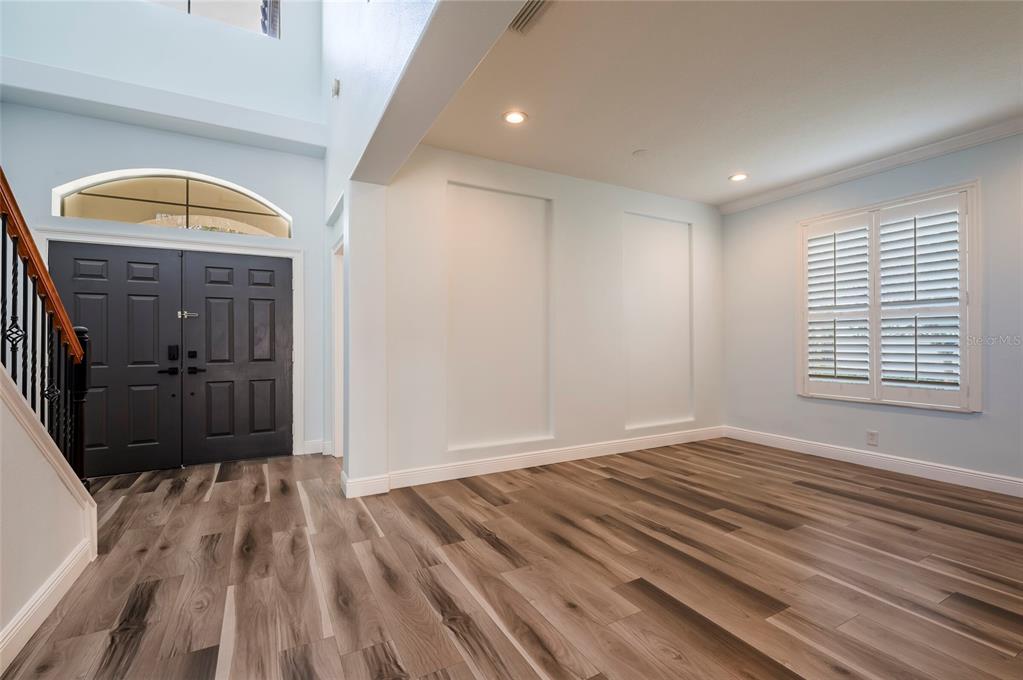 An entryway with wood-look flooring, a dark double door, and two recessed wall niches — 2348 MESSENGER CIRCLE, SAFETY HARBOR, FL