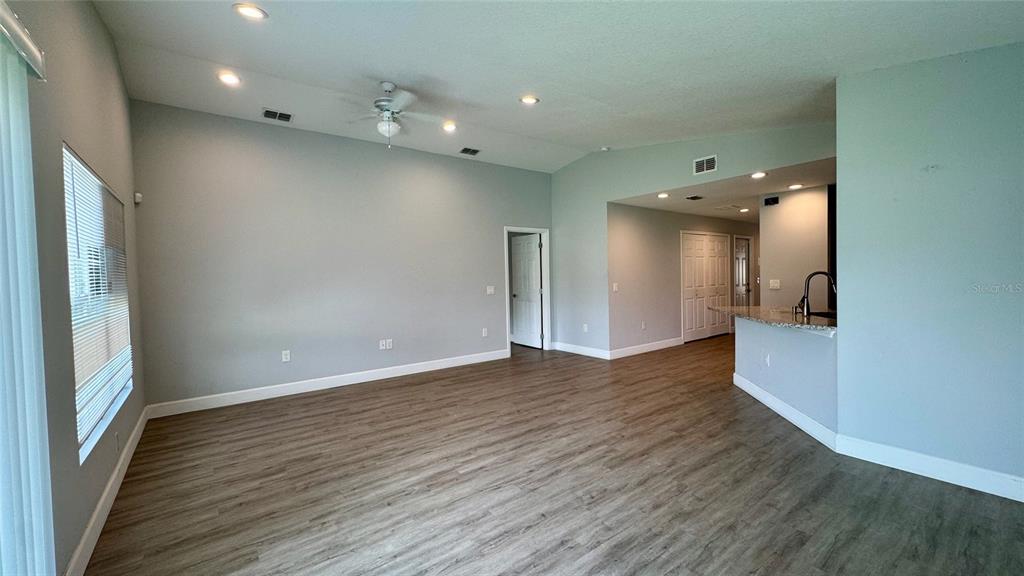 An open-concept living area features light gray walls, recessed lighting, and wood-look flooring — 5 N HART BOULEVARD, ORLANDO, FL