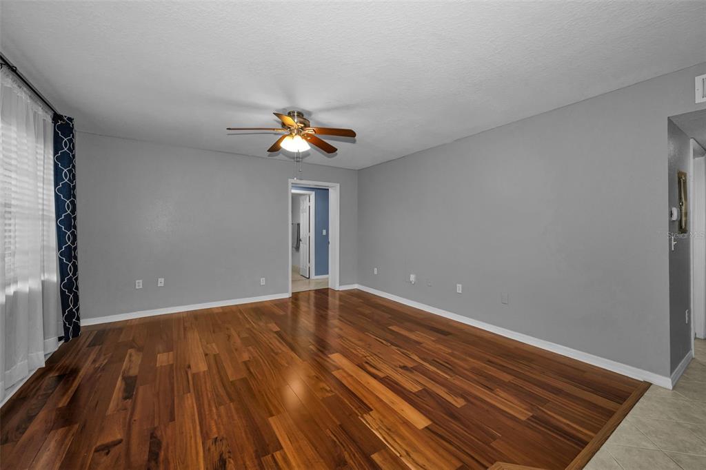 An empty room with gray walls, hardwood flooring, and a ceiling fan — 6100 GULFPORT BOULEVARD S UNIT 405, GULFPORT, FL