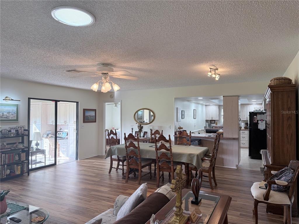 A dining area with a wooden table and chairs sits adjacent to a kitchen — 2417 LOCKSLEY STREET UNIT 229, SUN CITY CENTER, FL