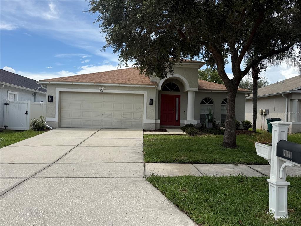 This real estate flyer displays a house exterior, kitchen, bathroom, garage, and backyard features — 7341 PULTENEY DRIVE, WESLEY CHAPEL, FL