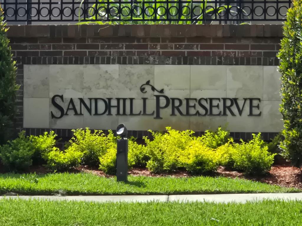 A brick and stone monument sign displays the name Sandhill Preserve in a landscaped area — 2415 SAND ARBOR CIRCLE, ORLANDO, FL