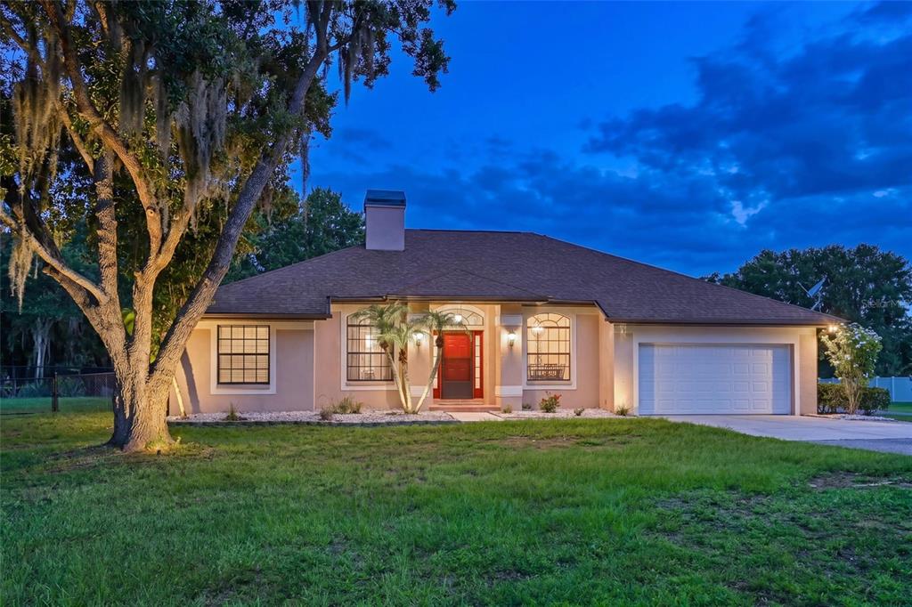 A single-story house with a red front door, a two-car garage, and a large tree — 4415 N RYE ROAD, PARRISH, FL