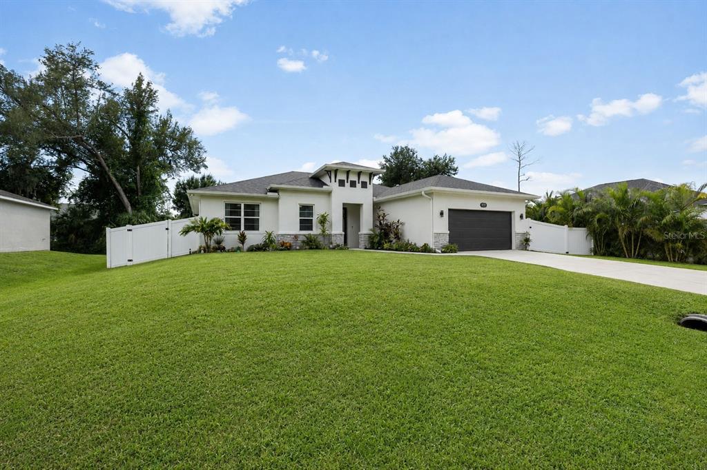 A single-story house with a white exterior, stone accents, and a two-car garage — 4033 UNION LANE, NORTH PORT, FL