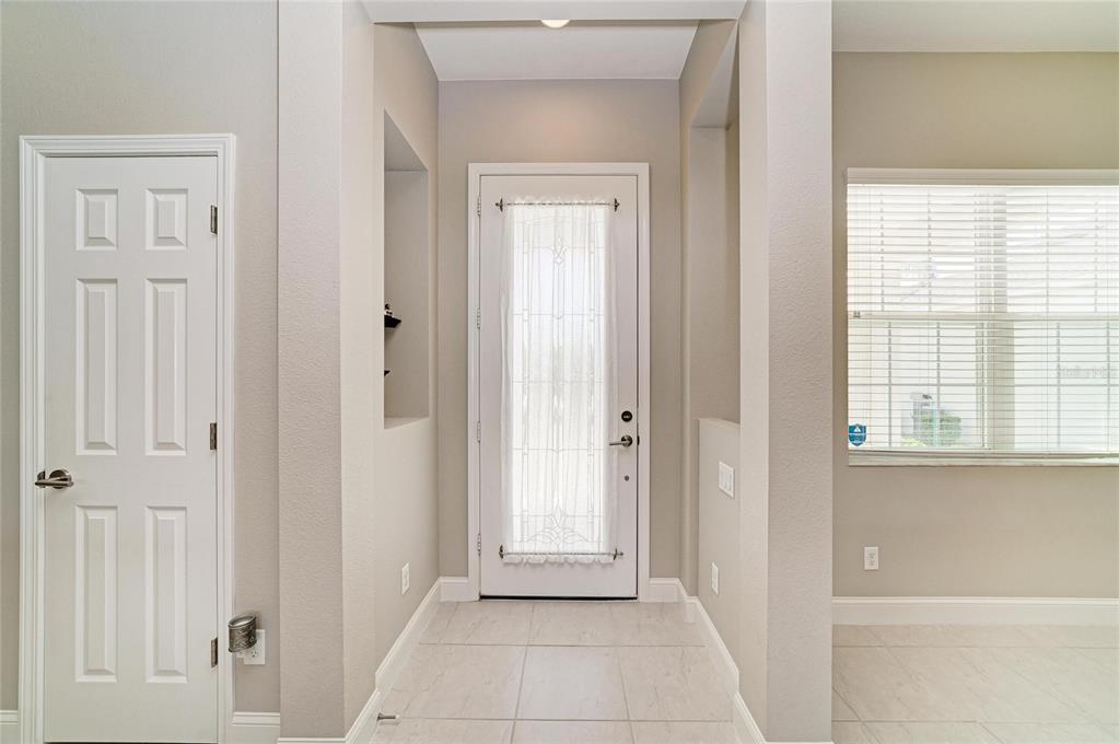 An entryway features a white front door with a glass insert, tile flooring, and neutral walls — 3835 CREEKSIDE PARK DRIVE, PARRISH, FL