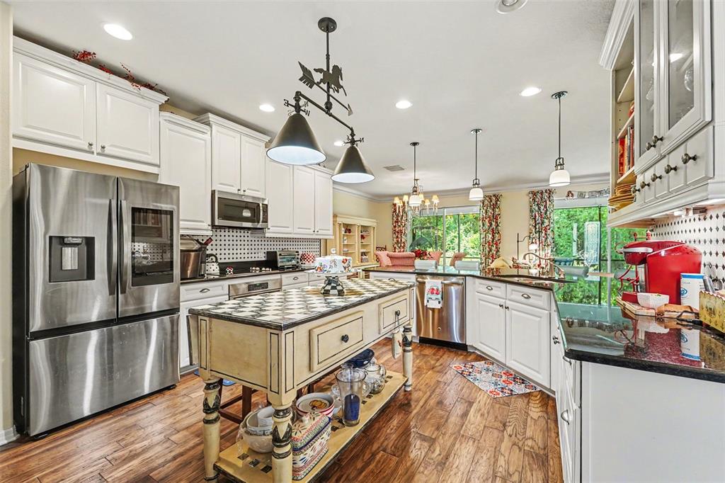 A kitchen features white cabinets, stainless steel appliances, and a checkered-top wooden island — 10202 HYANNISPORT LOOP, SAN ANTONIO, FL