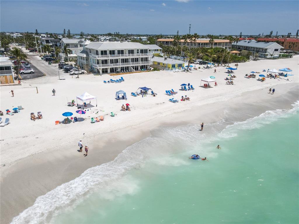 An aerial view shows a multi-story beach resort building situated along a sandy shoreline — 101 66TH STREET UNIT 6, HOLMES BEACH, FL