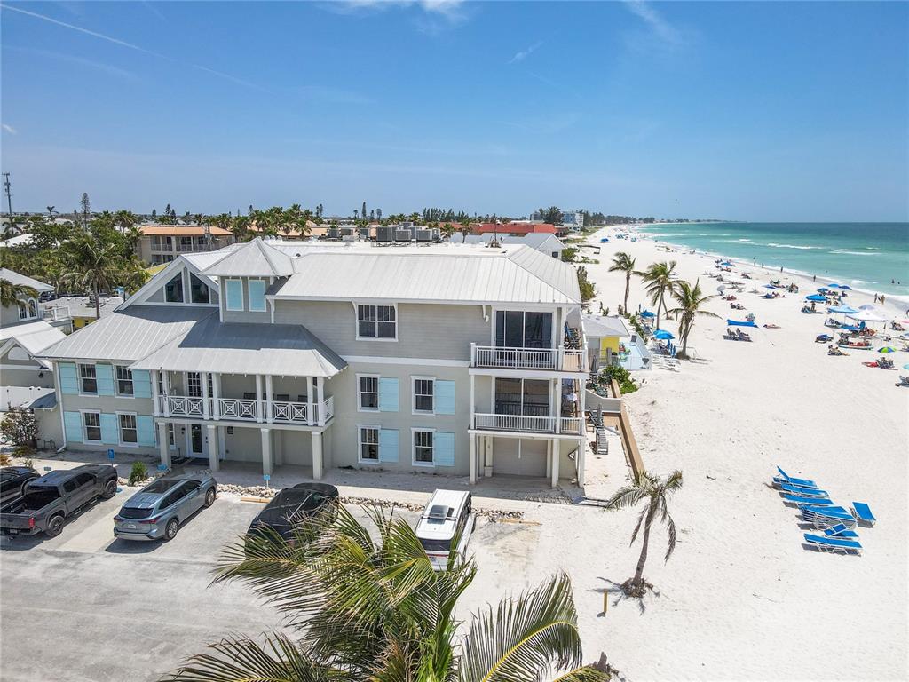 An aerial view shows a multi-story beach house with a metal roof and parking area — 101 66TH STREET UNIT 6, HOLMES BEACH, FL