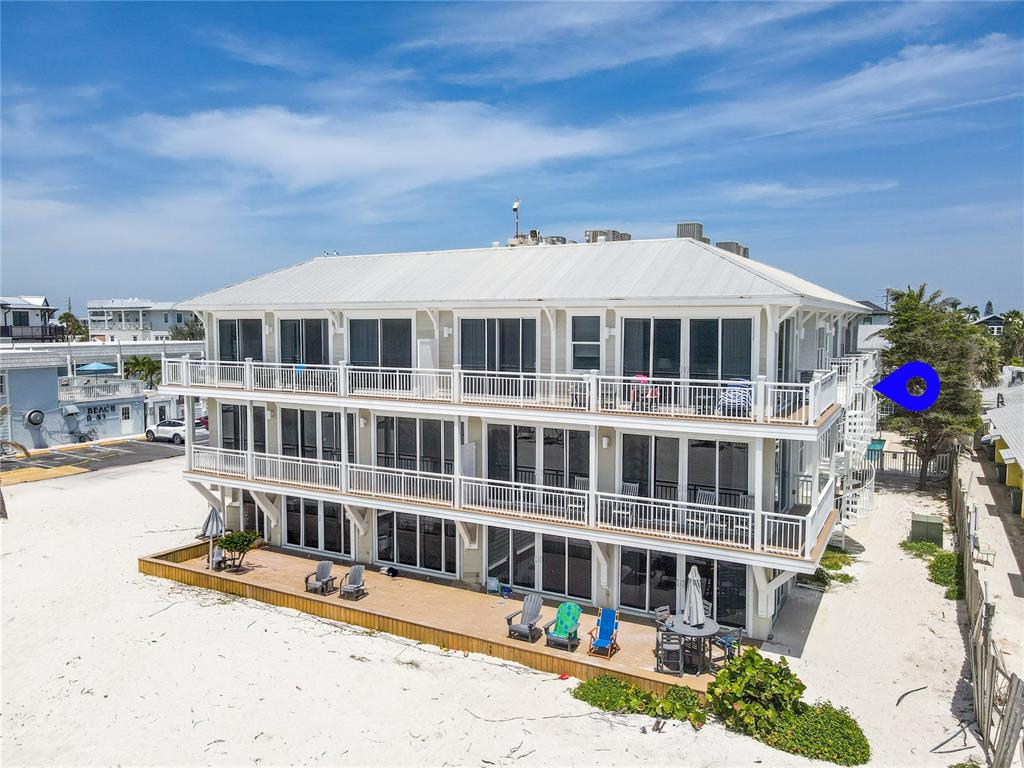 A three-story beachfront building features white siding, multiple balconies, and an exterior spiral staircase — 101 66TH STREET UNIT 6, HOLMES BEACH, FL